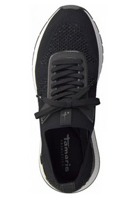Baskets de sport noires avec tige en mesh, lacets noirs noués en nœud, semelle blanche et marque "Tamaris Fashletics" à l'intérieur.