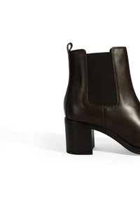 Braune Leder-Ankle-Boots mit elastischen Seiteneinsätzen, einer runden Zehenpartie und einem mittelgroßen Blockabsatz mit strukturierten Oberflächen.