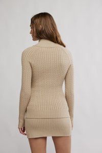 Μπεζ πλεκτό φόρεμα με υφή πλεξίματος τύπου καλώδιο και ριμπ τελείωμα. Μακριά μανίκια και ψηλός λαιμός με εφαρμοστή σιλουέτα.