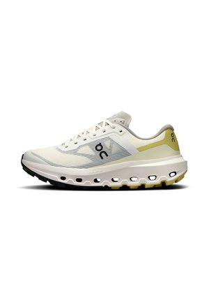Chaussure de course beige clair avec lacets blancs, tige en mesh respirant, semelle épaisse et rembourrée avec trous de ventilation, et accents jaunes subtils.