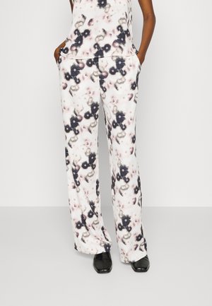 Pantalons amples à motif floral dans des couleurs claires avec des nuances de noir et de rose, fabriqués en tissu doux, dotés de poches latérales.
