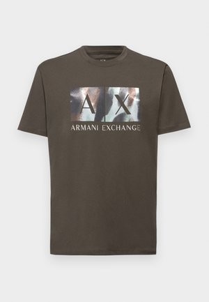 T-shirt in cotone marrone con una grande grafica recante "AX" e "Armani Exchange" in bianco, con una sovrimpronta testurizzata in tonalità di blu e marrone.