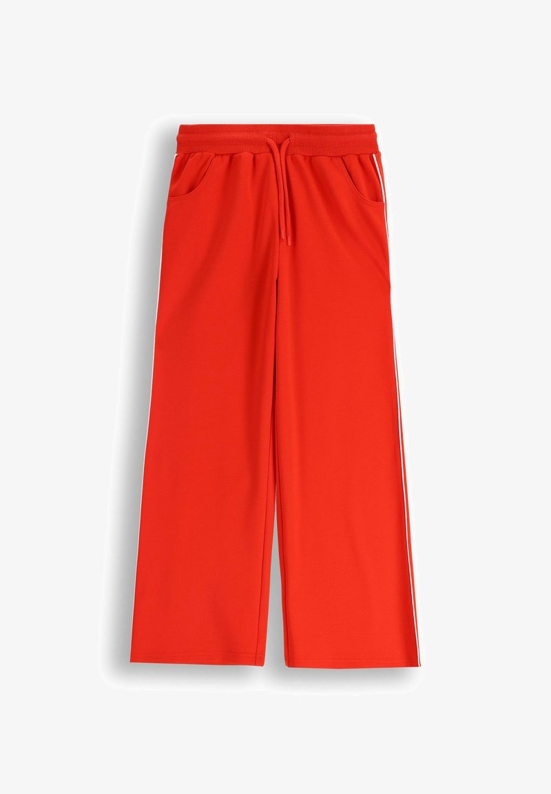 Czerwone, szerokie dresy wykonane z miękkiego materiału, z elastycznym pasem, sznurkiem i bocznymi kieszeniami. Posiadają białe boczne paski.