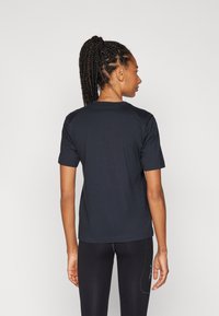 Schwarzes Baumwoll-T-Shirt mit kurzen Ärmeln, rundem Ausschnitt und lockerer Passform. Verfügt über eine glatte Textur und ein zurückhaltendes Design.