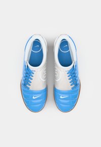 Blaue und weiße Sneakers verfügen über ein Obermaterial aus glattem Stoff mit einem gesteppten Design, einer Gummisohle und kontrastierenden blauen Schnürsenkeln. Nike-Logo an der Seite.