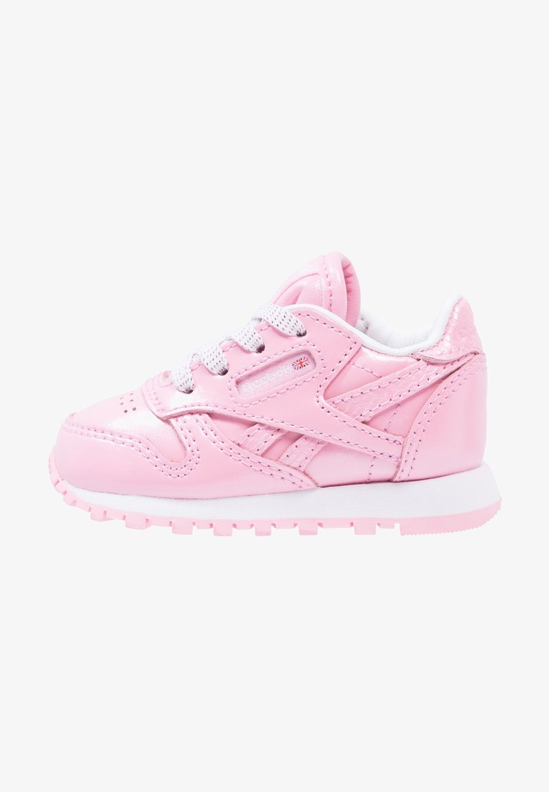 Baskets brillantes roses pour tout-petit avec lacets et semelle blancs, avec des détails cousus et un petit logo du drapeau britannique sur le côté.