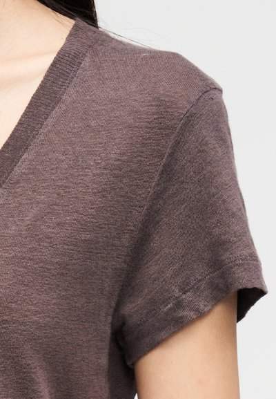 Top de manga curta com decote em V em cor malva suave. Feito de tecido leve e texturizado, com corte descontraído e decote canelado.