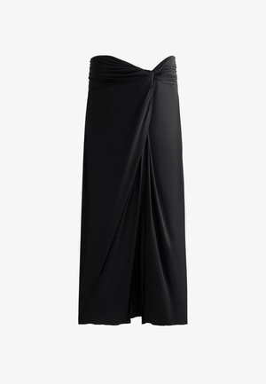 Crna suknja od mekanog tkanja s dizajnom naboranog izgleda. Ima uvijeni pojas i laskave prednje nabore.