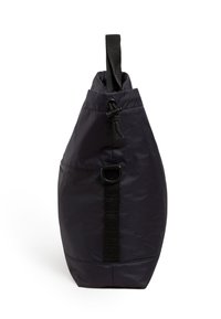 Bolso tote de nylon gris oscuro con forma alargada, que presenta un cierre superior con cordón, una correa ajustable y un detalle de lazo en el costado.