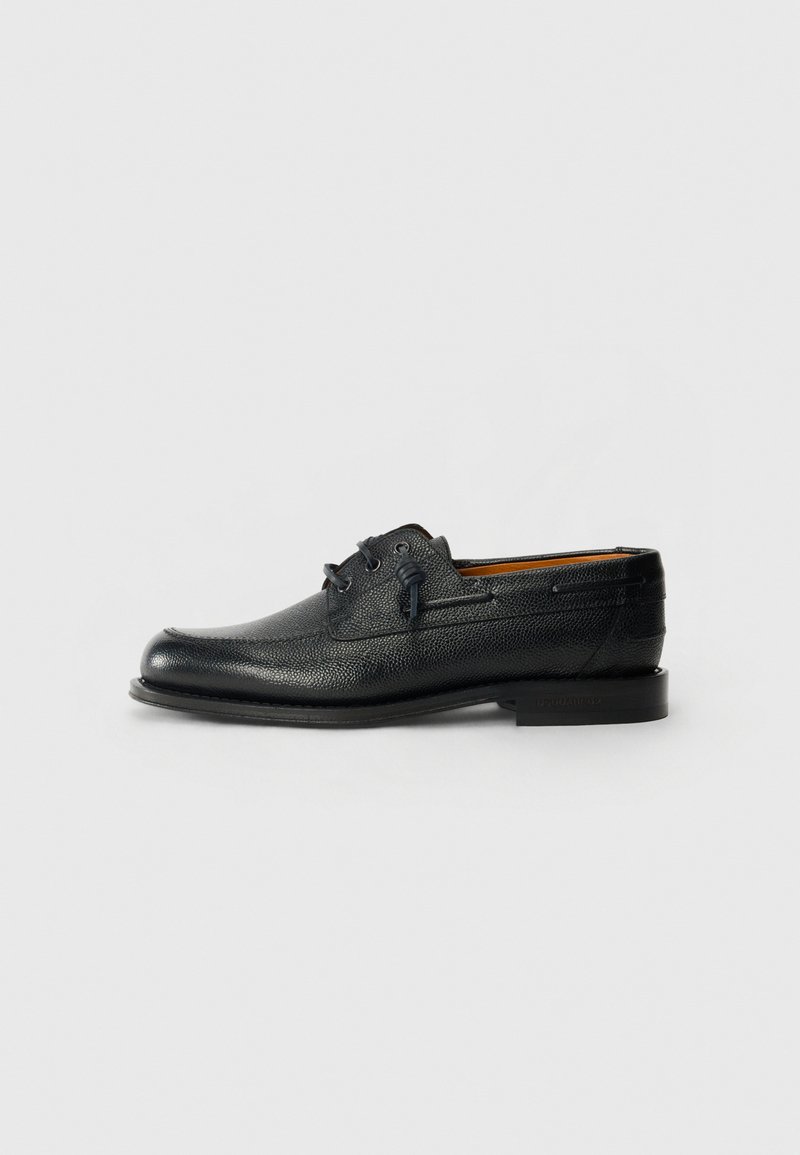 Black leather shoe with textured surface, round toe, and two eyelet lace-up design. Features a flat sole and minimalistic branding on side.