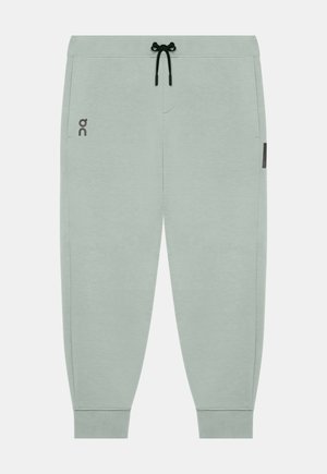 Pantaloni jogger grigio chiaro con coulisse nera, polsini elastici, tasche laterali e piccolo logo sulla coscia sinistra.
