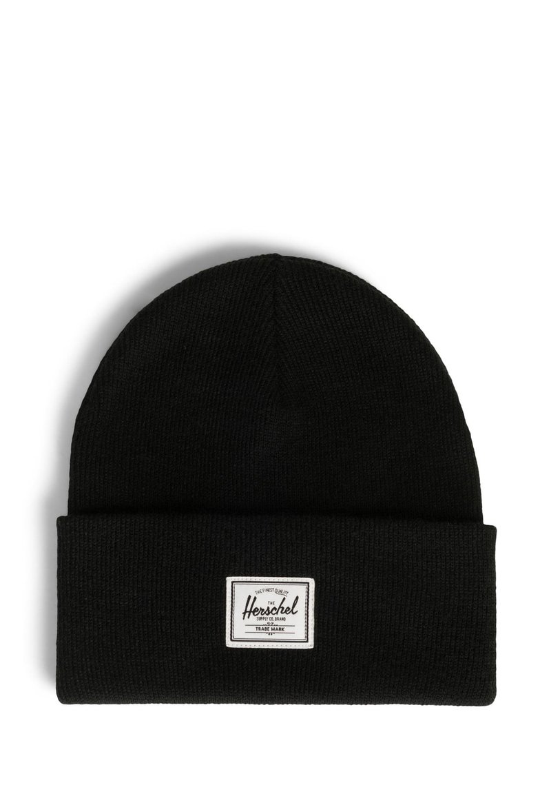 Gorro de punto negro con puño doblado, que presenta una etiqueta rectangular blanca con texto negro en un lado. Tejido suave y texturizado.