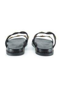 Infradito in pelle nera con cinturini decorati da accenti dorati, suola piatta, design aperto e soletta texturizzata per il comfort.