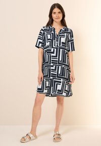 Kurzarmkleid in marineblauer und weißer geometrischer Musterung, mit Kragen und Knopfleiste, lockerer Schnitt, weicher Stoff und knielanges Design.