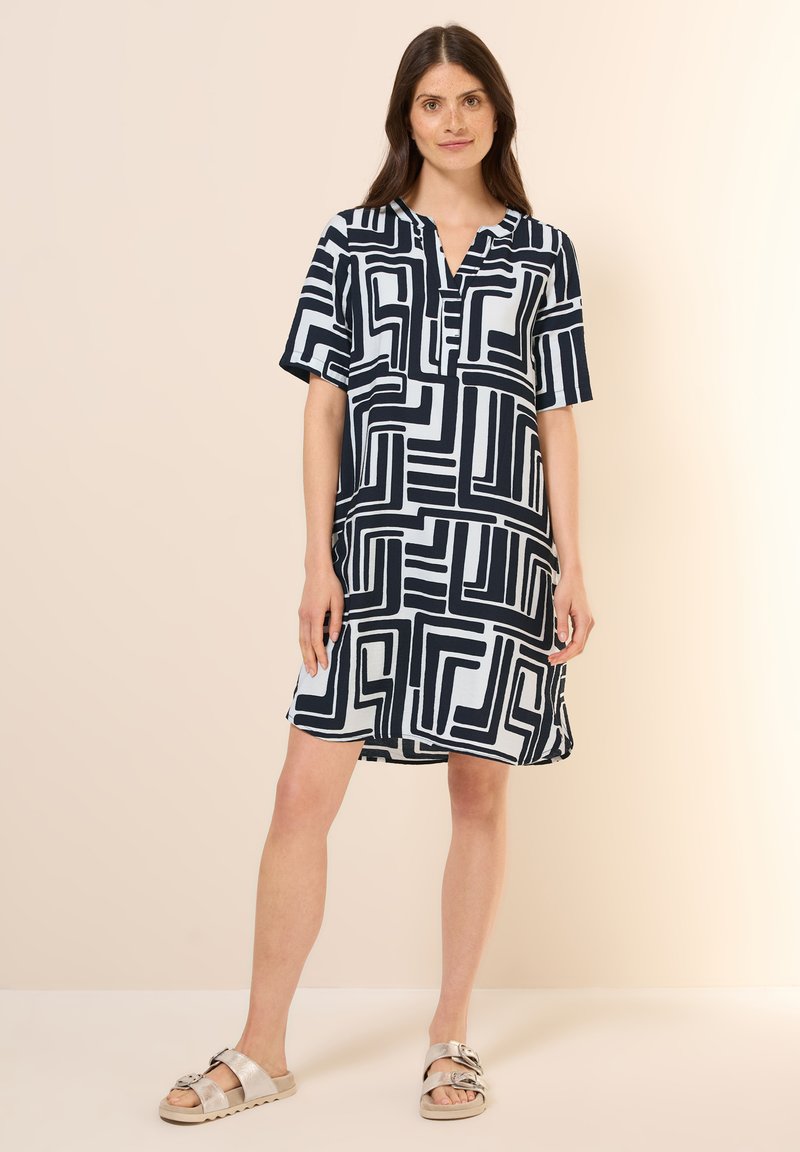 Kurzarmkleid in marineblauer und weißer geometrischer Musterung, mit Kragen und Knopfleiste, lockerer Schnitt, weicher Stoff und knielanges Design.