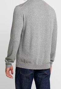 Grauer Strickpullover für Herren mit Rundhalsausschnitt, gerippten Bündchen und Saum. Weiche Textur, taillierte Passform und nahtlose Schulterdetails.