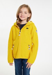 Gul zip-up hoodie med en texturerad finish, som har en paraplylogotyp, två fickor med dragkedja och dekorativa fransar på dragkedjorna.