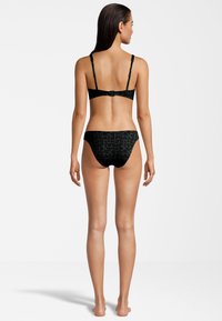 Set di bikini nero con motivo texturizzato e logo. Spalline sottili regolabili e cosciale a copertura media con una finitura liscia.