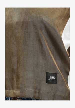 Kortærmet skjorte i skinnende bronze stof med hvide detaljer. Har et sort mærke med "Sixth June Paris" i nederste venstre hjørne.