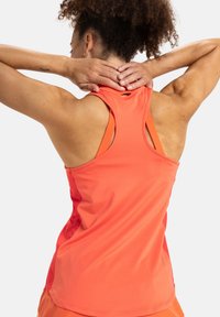 Helles korallenfarbendes Sport-Tanktop mit Racerback-Design, kontrastierendem orangefarbenem Innenfutter und glatter, feuchtigkeitsableitender Stoffoberfläche.