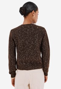 Maglione brown lavorato a maglia con un motivo a macchie, collo rotondo, maniche lunghe e orlo a coste, con una finitura testurizzata e una vestibilità rilassata.