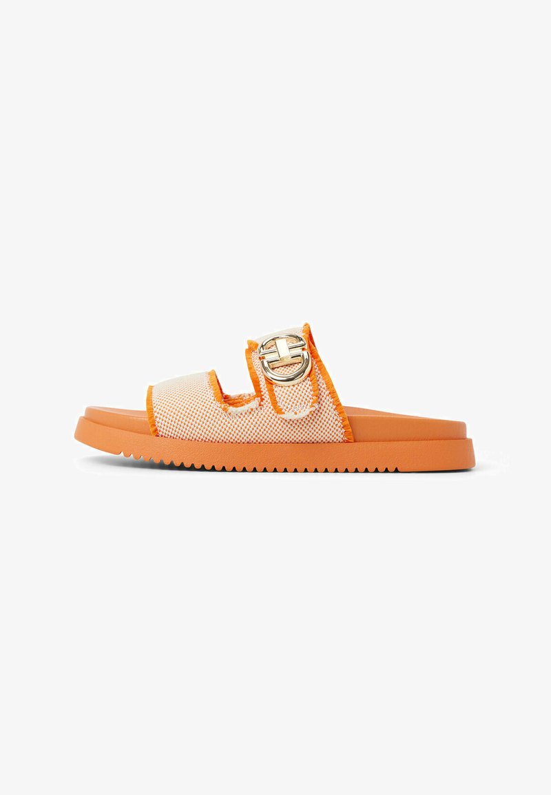Sandale orange à glissière avec tige en maille et semelle en caoutchouc. Présente une boucle argentée et un bord texturé. Base plate avec rainures d'adhérence.