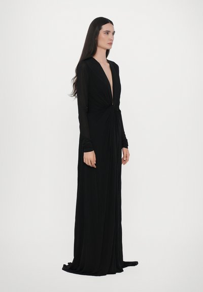 Vestido largo negro de manga larga con escote en V profundo, cintura ceñida y falda de largo hasta el suelo. Hecho de una tela suave y fluida.