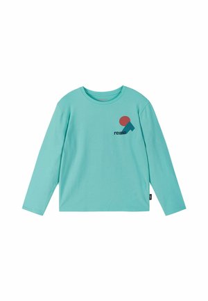 Jasnoniebieska koszula z długim rękawem, okrągłym dekoltem oraz małym czerwono-niebieskim geometrycznym logo nad czarnym tekstem "reima" na lewej piersi.
