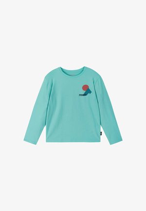 Light blue long-sleeve shirt with round neck and small red and blue geometric logo above black "reima" text on the left chest.