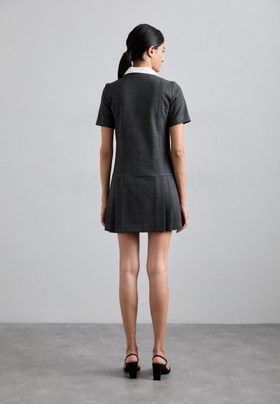 Rochie cu mânecă scurtă, gri în carouri, cu fustă pliată și guler alb. Confecționată dintr-un material adaptat, prezentând o siluetă elegantă și detalii minime.