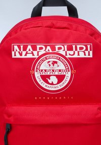 Zaino rosso con spallacci neri, caratterizzato da audaci loghi bianchi e dorati e da un design circolare con una mappa del mondo e la silhouette dell'Antartide.