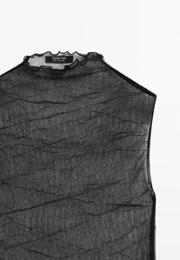 Černý tílkový top z průsvitné, mačkané látky s vysokým volánkovým límcem a jemným strukturovaným vzorem. Na krku je viditelná značka značky.