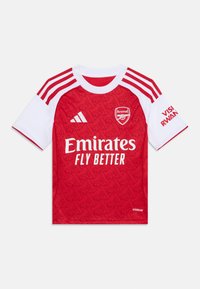 Rød fotballskjorte med hvite detaljer, med teksturert mønster, rund hals og broderte logoer. Inkluderer teksten "Emirates Fly Better".