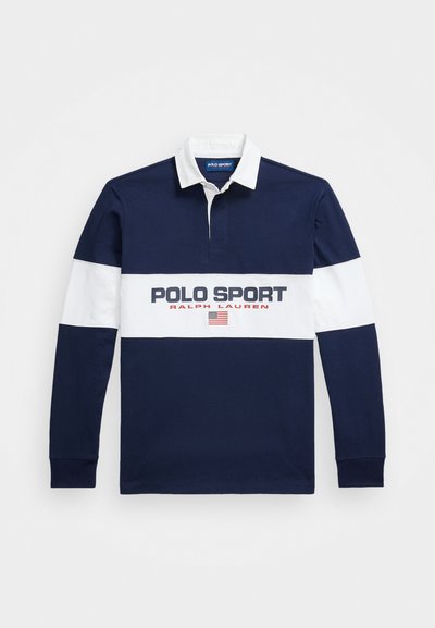 Tumši zils garām piedurknēm polo krekls ar baltiem akcentiem, ar ribotu apkakli, pogu slēgšanu un lielu "POLO SPORT" logotipu uz krūšu.