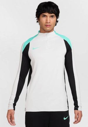 Langemouwen sportshirt in wit met zwarte mouwen en turquoise accenten, voorzien van een kwart-rits kraag en het Nike-logo op de borst.