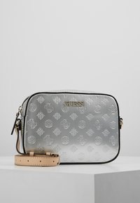 Borsa a tracolla sintetica argentata con motivi geometrici in rilievo, ferrature dorate e tracolla rimovibile color beige chiaro. Rifiniture nere lungo i bordi.