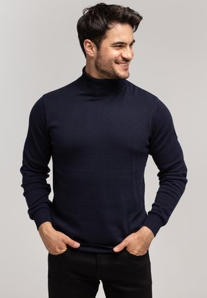 Granatowy sweter z golfem wykonany z miękkiego materiału, z długimi rękawami, ściągaczami na mankietach i dopasowanym krojem.