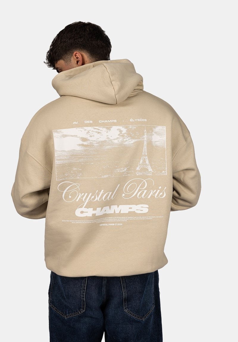 Béžová mikina s kapucí, na zadní straně s grafickým potiskem Eiffelovy věže a nápisy "Crystal Paris" a "AV. DES CHAMPS-ÉLYSÉES."