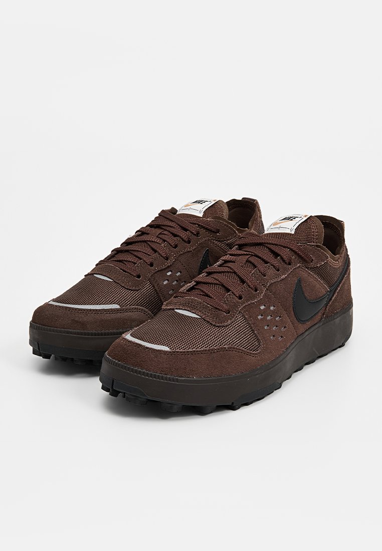 Baskets marron en suède et en maille, avec une pointe ronde, des lacets foncés et un accent logo noir. Semelle texturée pour une meilleure adhérence.