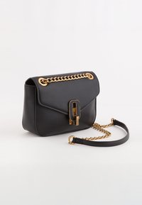 Bolso sintético negro con acabado texturizado, acento de cadena dorada, cierre de clip y correa desmontable. Forma rectangular y diseño minimalista.