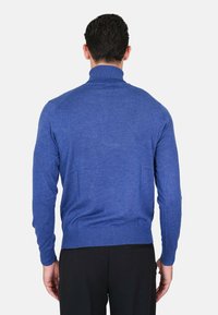 Maglione blu a maglia con colletto alto. Presenta polsini e orlo a coste, una texture liscia e un design aderente, visto da dietro.