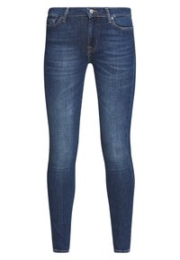 Tmavě modré skinny džíny s mírným vyblednutím, pětipocketový styl, zapínání na knoflík a viditelné švy na bílém pozadí.