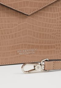 Borsa in pelle color tan con motivo coccodrillo, dotata di una chiusura in argento e del nome del marchio "SEIDENFELT MANUFAKTUR" impresso.