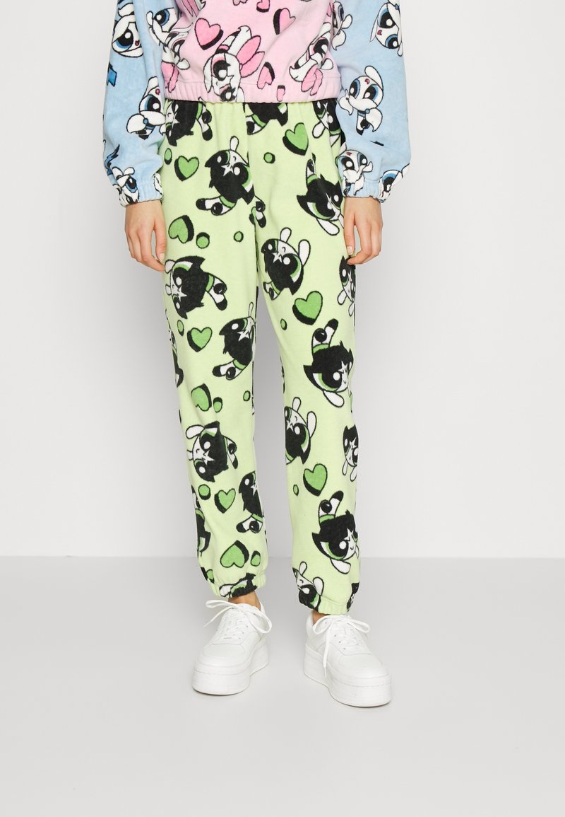Fleece-Pyjamahosen in Hellgrün mit schwarz-weißen Cartoon-Tiermotiven und Herzmustern; elastischer Bund und schmal zulaufende Bündchen.