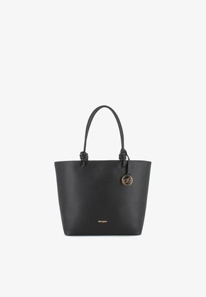 Bolso tote de cuero negro con dos asas anudadas y un pequeño colgante redondo dorado en el asa derecha.