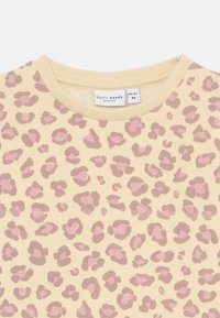 Top a maniche lunghe con stampa leopardo gialla crema e macchie rosa testurizzate. Presenta un collo a costine e un'etichetta che indica la taglia 1½-2Y.