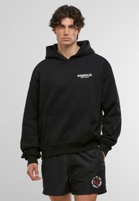 Černá mikina s kapucí, přední kapsou a stahovací šňůrkou, s bílým logem na levé hrudi. Nosit s černými šortkami.