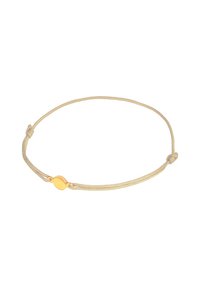 Guldtonad oval charm på ett ljusbeige snörarmband, med justerbara knutar för storleken och en slät textur.