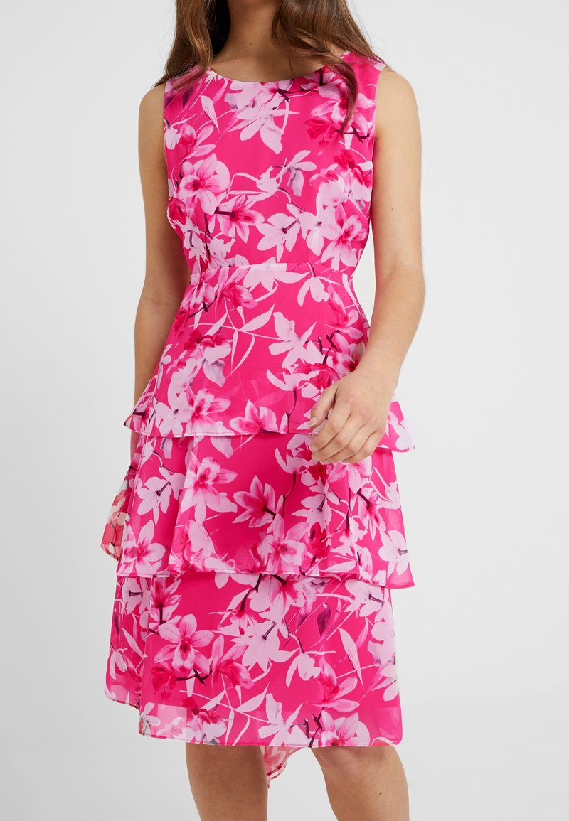 Pink floral dress with layered ruffles, featuring a round neckline and sleeveless design. The fabric is lightweight and has a smooth texture.