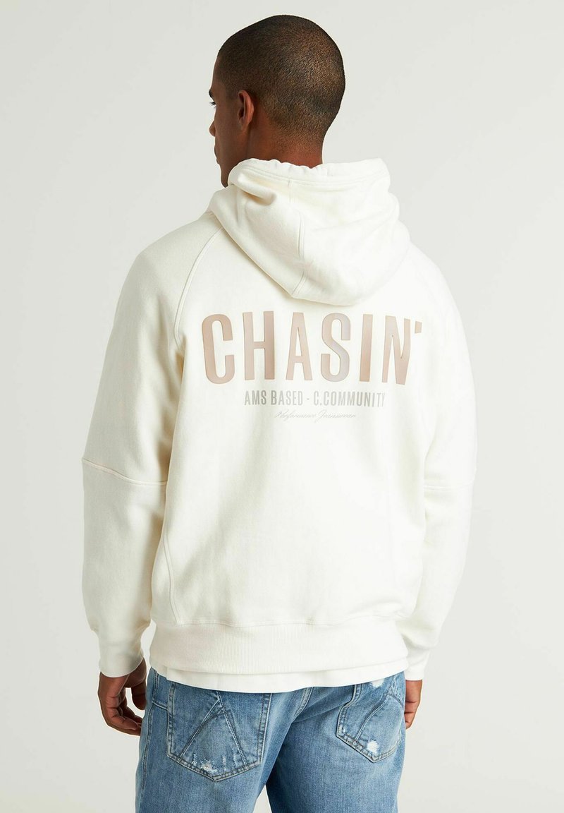 Off-white hoodie van zacht katoen met een kangoeroe-pocket. Beschikt over een opvallende grafische print op de achterkant met "CHASIN'" in lichtbruin.